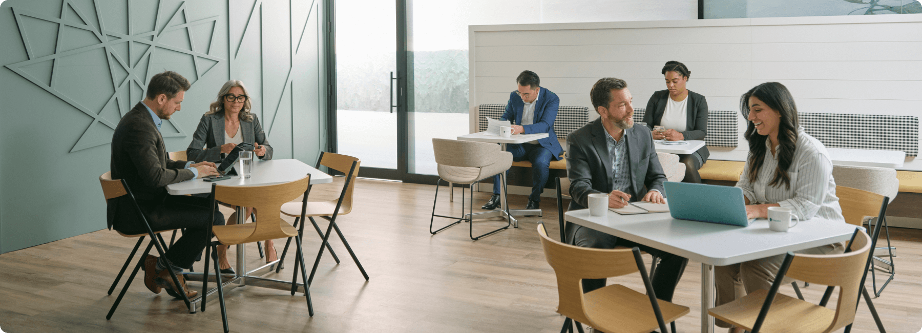 six collègues en train de travailler dans une salle à dîner