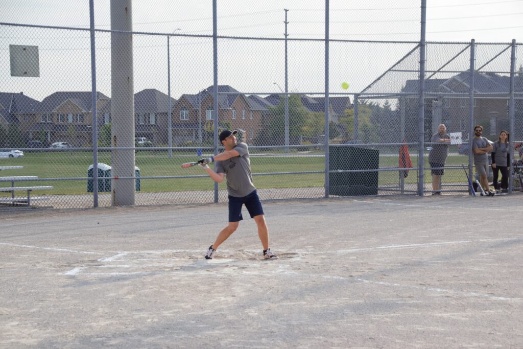 A player with his bat retracted preparing t hit a ball.